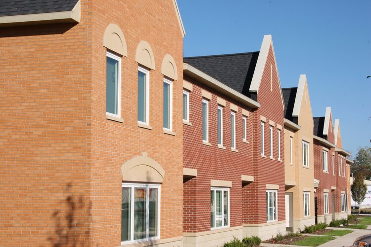 A line of brick housing buildings extending out of the scene.