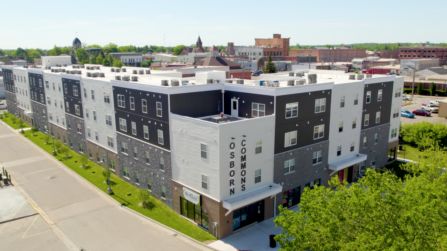 Aerial view of large, multi-story brick building reading "Osborn Commons" on its side.