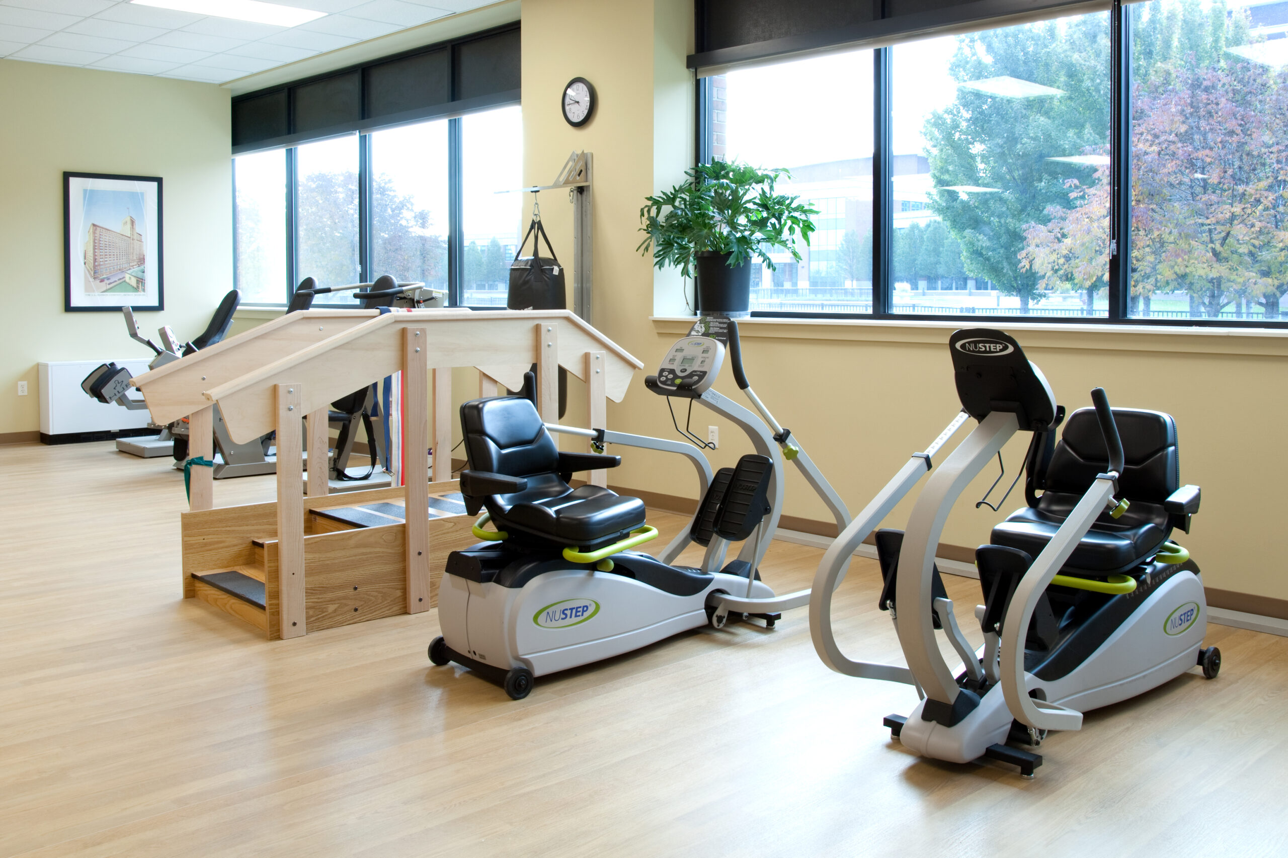 Interior of the PVM Thome Rivertown Neighborhood Exercise Room. Exercise machines, a stair climber, and a boxing bag can be seen.