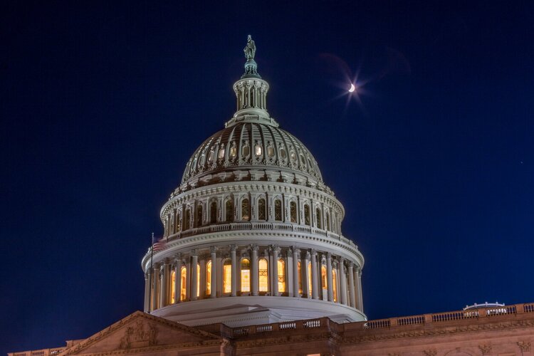 Exterior of the United States Capitol building at night.