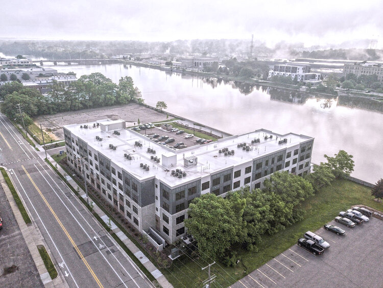 Aerial view of a large, gray, multi-story apartment building in Grand Rapids, Michigan.