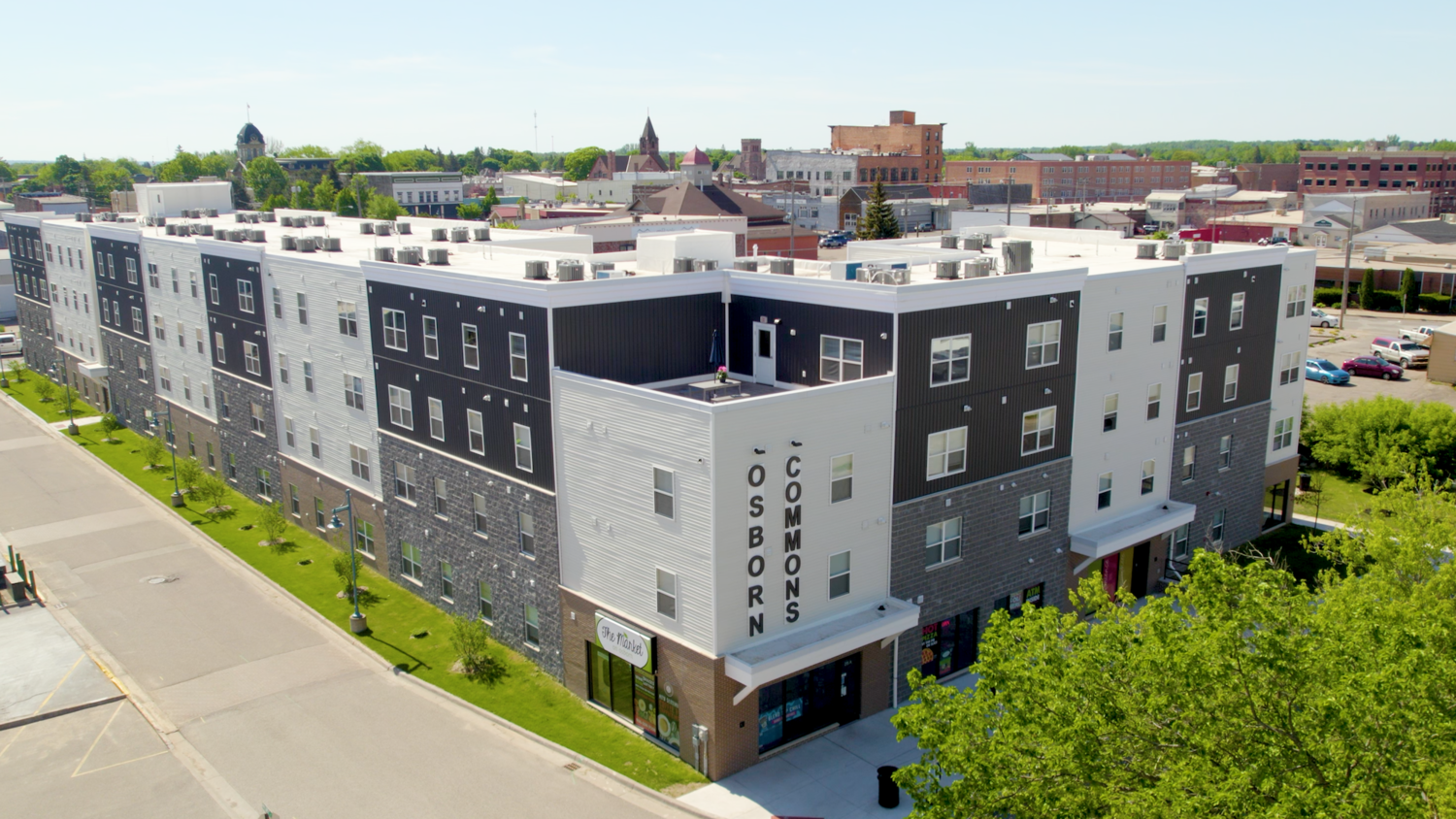 Aerial view of large, multi-story brick building reading "Osborn Commons" on its side.
